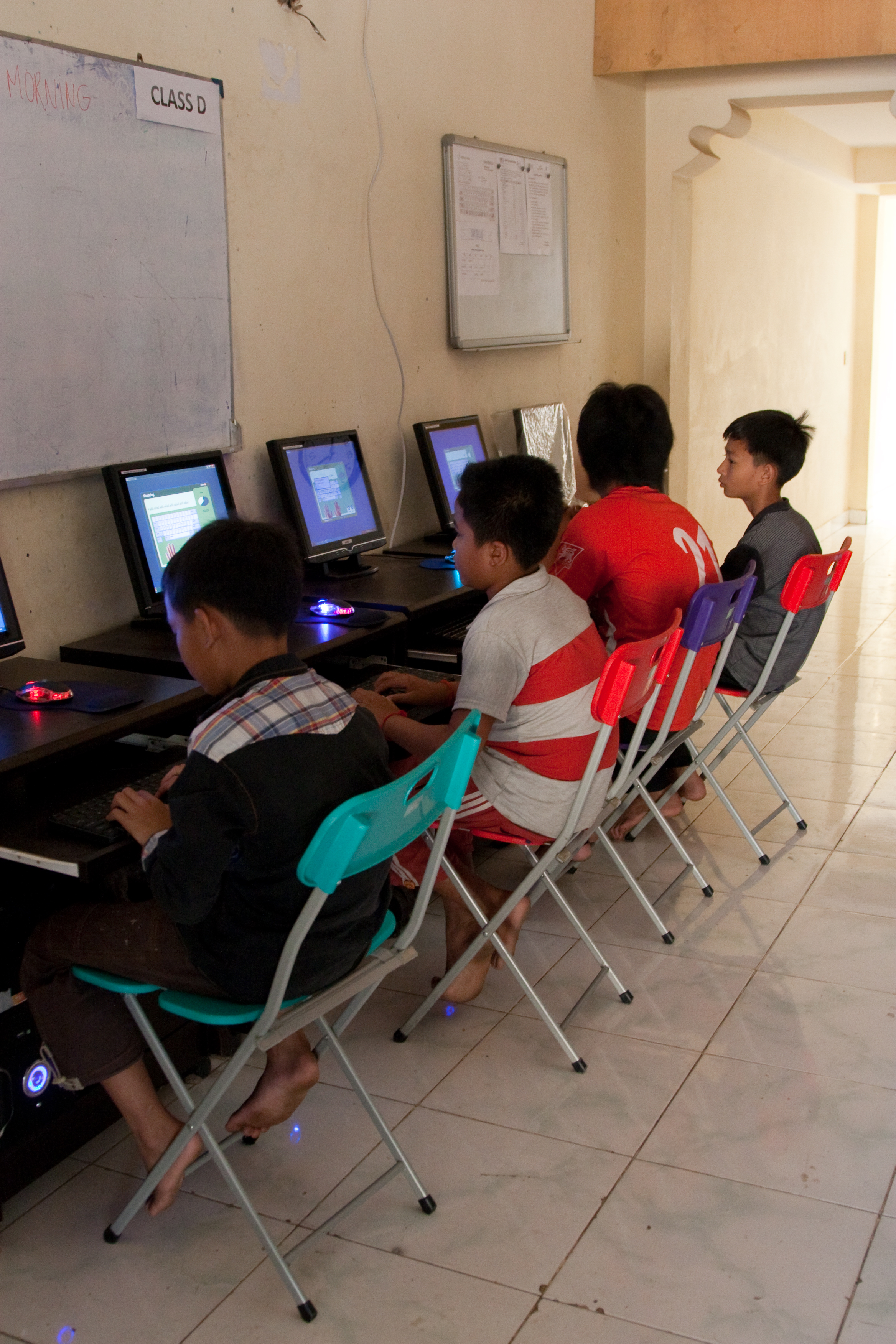 Kinderen die computerles van vrijwilligers in Cambodja krijgen